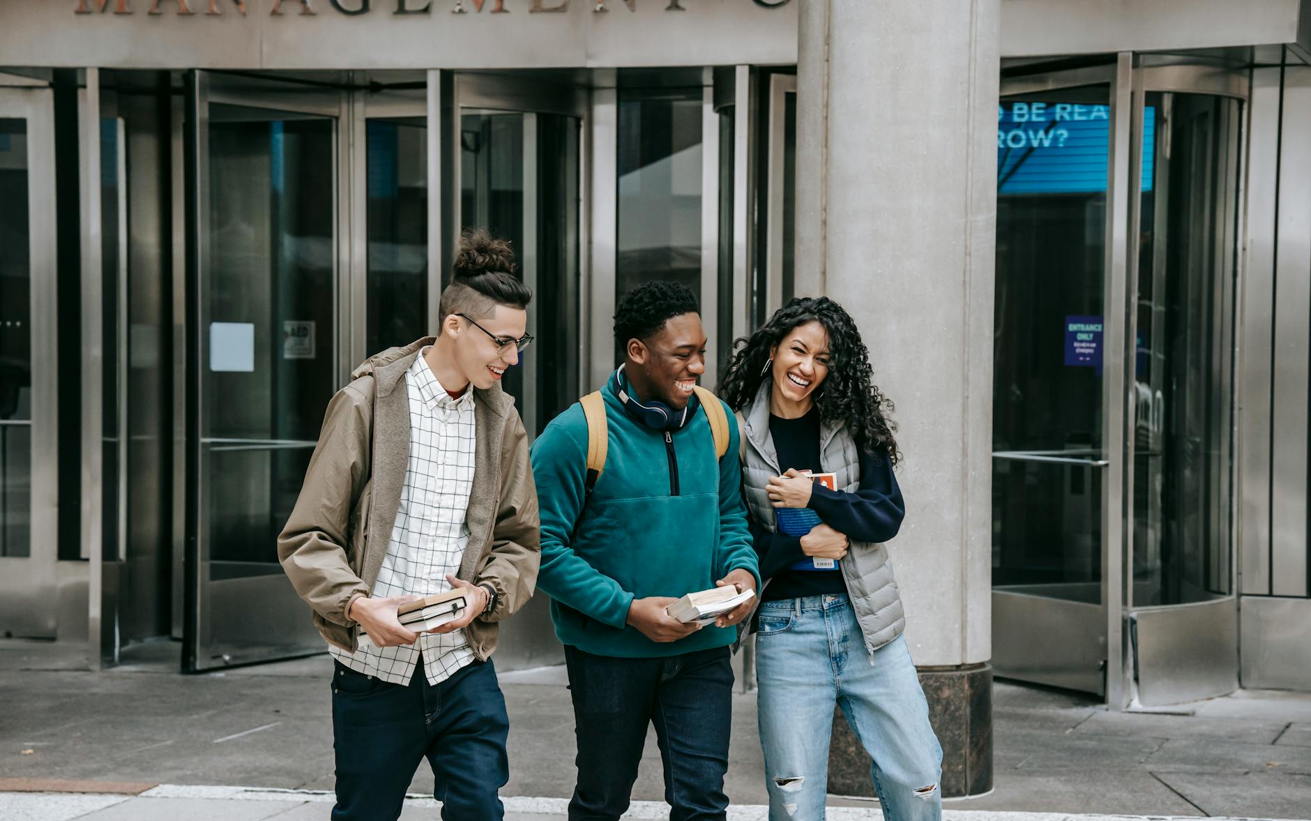 Trio laughing in front of business building 